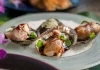 ʻOpihi on the Shell with Lomi ʻŌʻio by Brad Mira Recipe card photo of opihi on the shell garnished with green onions and unagi sauce