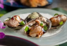 ʻOpihi on the Shell with Lomi ʻŌʻio by Brad Mira Recipe card photo of opihi on the shell garnished with green onions and unagi sauce