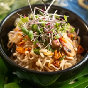 Pot of simmering shoyu ramen broth with mushrooms and ramen noodles being prepared by Brian Moon