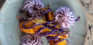 Ube Haupia Cheesecake Eggrolls By Chef Mari Wills Crispy ube haupia cheesecake eggrolls drizzled with purple ube sauce and served with whipped cream on a plate.